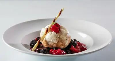 a white plate with a dessert with ice cream and berries at Holiday Inn Edmonton South - Evario Events by IHG in Edmonton