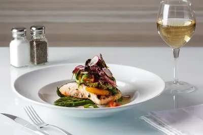 a white plate of food and a glass of wine at Holiday Inn Edmonton South - Evario Events by IHG in Edmonton