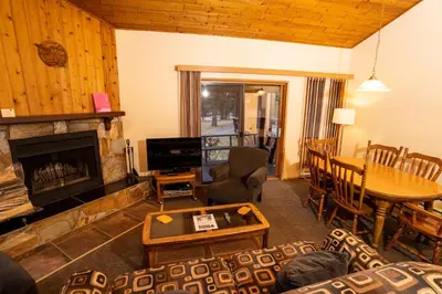 a living room with a fireplace and a table at Fairmont Hot Springs Resort in Fairmont Hot Springs