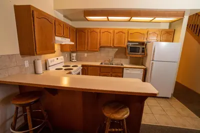 a kitchen with wooden cabinets and a white refrigerator at Fairmont Hot Springs Resort in Fairmont Hot Springs
