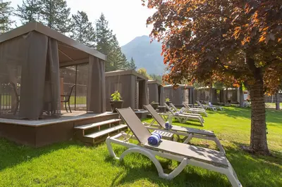 a row of chaise lounges in the grass near a building at Fairmont Hot Springs Resort in Fairmont Hot Springs
