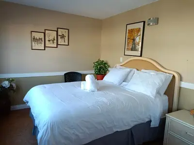 a bedroom with a large bed with white sheets at Painted Turtle Guesthouse in Nanaimo