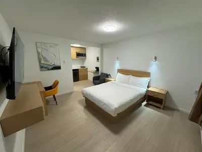 a bedroom with a bed and a desk and a television at Inntowne Motel in Hope