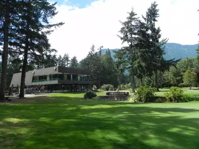 a large house in the middle of a green field at Skagit Motel in Hope
