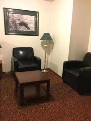 a living room with two chairs and a table and a lamp at Spring Villa Hotel in Harrison Hot Springs