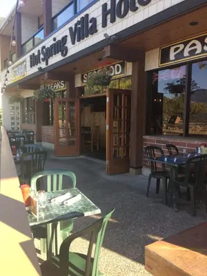 a restaurant with tables and chairs in front of a building at Spring Villa Hotel in Harrison Hot Springs