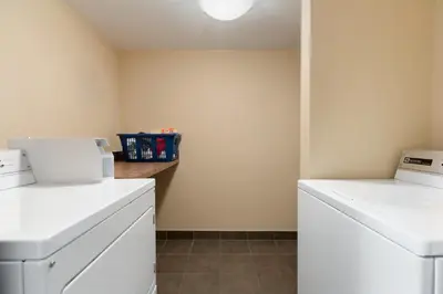 a laundry room with white washers and a counter at Days Inn by Wyndham Calgary Northwest in Calgary