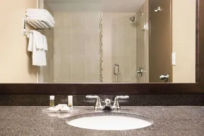 a bathroom with a sink and a large mirror at Days Inn by Wyndham Calgary Northwest in Calgary
