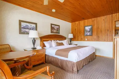 a bedroom with a bed and a desk and a table at The Crossing in Saskatchewan River Crossing
