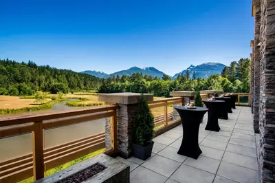 a balcony with tables and a view of the mountains at Executive Suites Hotel and Resort, Squamish in Squamish