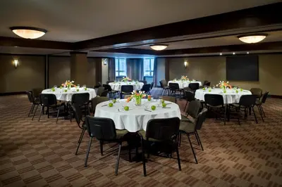 a room with several tables and chairs with white tablecloths at Executive Suites Hotel and Resort, Squamish in Squamish