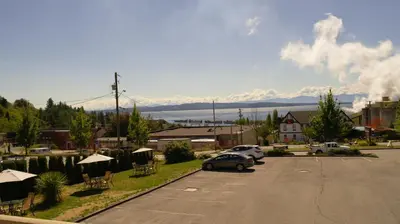 a car parked in a parking lot with mountains in the background at Island View Lodge in Powell River