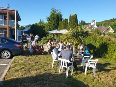 a group of people sitting in chairs in the grass at Island View Lodge in Powell River