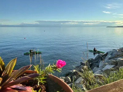 two people are sitting on kayaks in the water at Blitz Beach House Oceanside Suite in Powell River