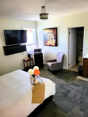 a hotel room with a bed and a chair at Royal Duke Hotel in Okotoks