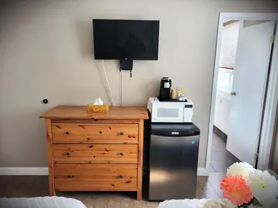 a microwave sitting on top of a dresser with a refrigerator at Royal Duke Hotel in Okotoks