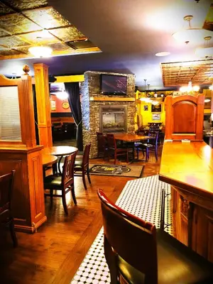 a restaurant with tables and chairs and a fireplace at Royal Duke Hotel in Okotoks