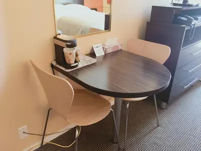 a table in a room with two chairs and a mirror at Riverside Motel Cache Creek in Cache Creek