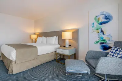 a hotel room with a bed and a chair at Bayside Resort, an Ascend Collection Resort in Parksville