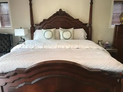 a large wooden bed with two pillows on it at Royalty B&B in Richmond