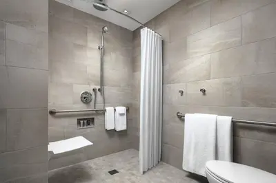 a bathroom with a shower and a toilet and towels at JW Marriott Edmonton ICE District in Edmonton