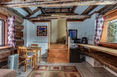 a room with a table and a kitchen with wooden ceilings at Nakiska Bear Ranch in Clearwater