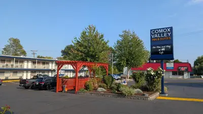 a parking lot with a sign in front of a building at Comox Valley Inn & Suites in Courtenay