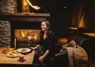 a woman sitting at a table with a plate of food at The Explorer Hotel in Yellowknife