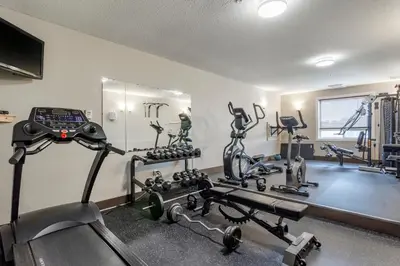 a gym with several treadmills and exercise machines at Devonian Hotel and Suites in Fox Creek
