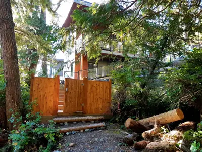 a wooden fence in front of a house at Storm Cove Suites in Ucluelet
