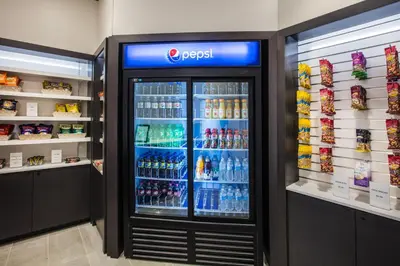 a drink cooler in a store with drinks in it at Holiday Inn & Suites Grande Prairie by IHG in Grande Prairie