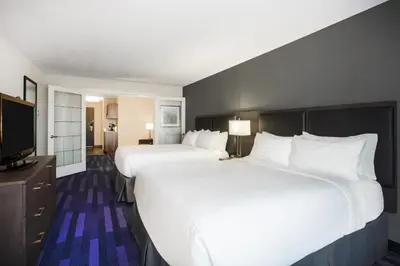 a hotel room with two beds and a flat screen tv at Holiday Inn & Suites Grande Prairie by IHG in Grande Prairie
