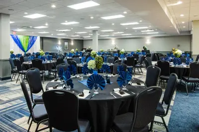 a banquet hall with tables and chairs with blue bows at Holiday Inn & Suites Grande Prairie by IHG in Grande Prairie