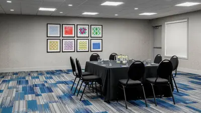a conference room with a table and black chairs at Holiday Inn Express Airdrie by IHG in Airdrie