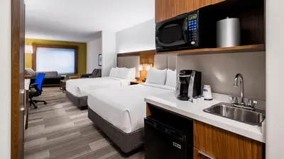 a hotel room with two beds and a sink at Holiday Inn Express Airdrie by IHG in Airdrie