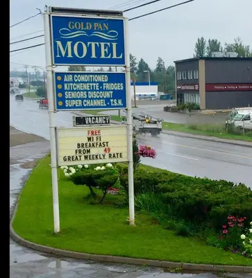 a sign for a motel on the side of a road at Gold Pan Motel in Quesnel