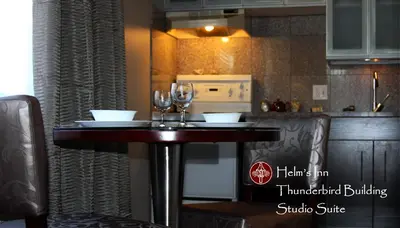a table in a kitchen with two wine glasses on it at Helm's Inn in Victoria