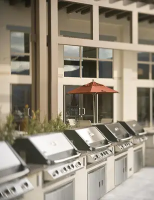 a row of sinks with an umbrella in front of a building at Walnut Beach Resort in Osoyoos