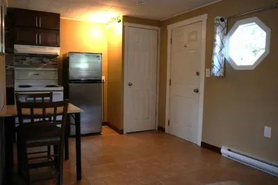 a kitchen with a table and a refrigerator at Malahat Bungalows Motel in Malahat