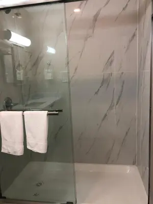 a bathroom with a glass shower with white towels at Vancouver shaughnessy guest home in Vancouver