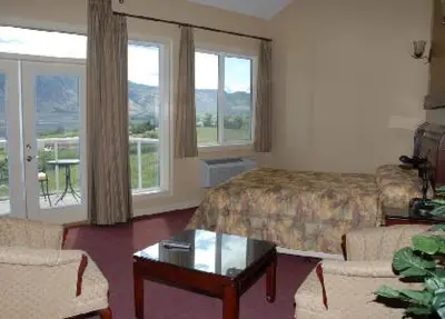 a hotel room with a bed and a table and chairs at Ciliegia Villa in Osoyoos