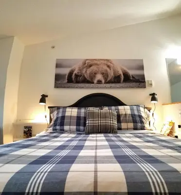 a bed with a picture of a brown dog on the wall at Downtown Loft, Mountain Views, Fireplace, Couple's Retreat, Walker's Paradise in Canmore