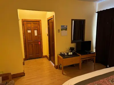 a room with a bed and a desk with a television at Rodmay Hotel in Powell River