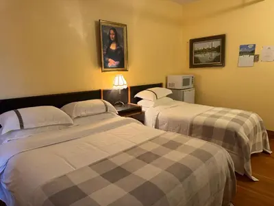 a hotel room with two beds and a microwave at Rodmay Hotel in Powell River