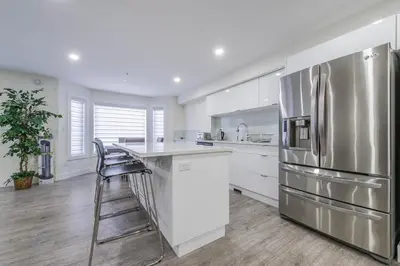 a kitchen with white cabinets and a stainless steel refrigerator at Private Vacation Guest Suite Near Beach in White Rock