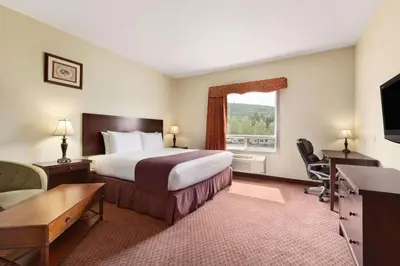 a hotel room with a bed and a window at Days Inn by Wyndham Chetwynd in Chetwynd