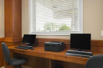 two computers sitting on a desk with a computer printer at Days Inn by Wyndham Chetwynd in Chetwynd