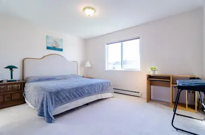 a bedroom with a bed and a desk and a window at 3 Private, spacious, bright rooms in a Gorgeous house in New Westminster