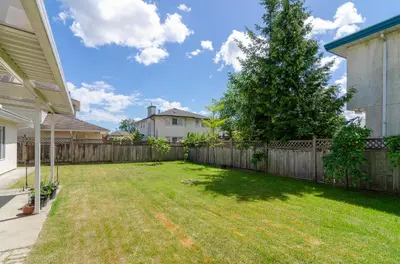 a yard with a fence and a tree at 3 Private, spacious, bright rooms in a Gorgeous house in New Westminster