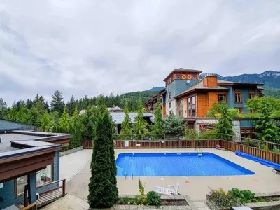 a house with a swimming pool in front of a house at Newly Renovated Whistler Studio in Whistler